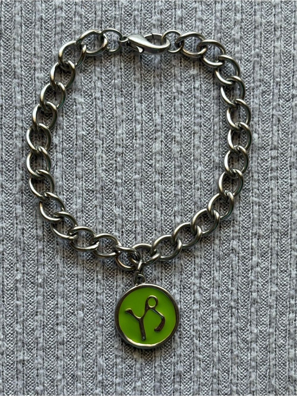 Silver tone chain bracelet with green Capricorn zodiac charm
